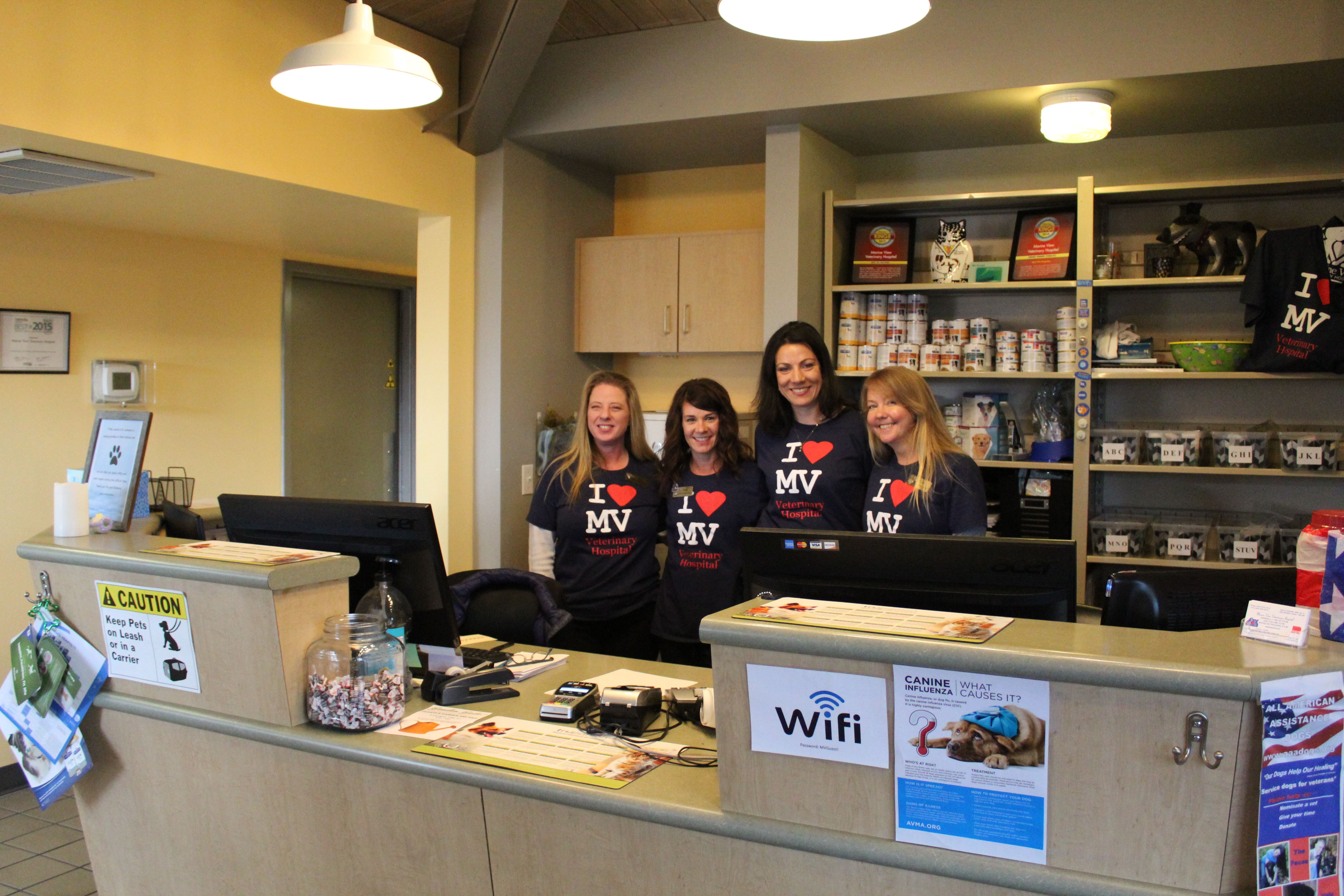 Four staff members behind desk