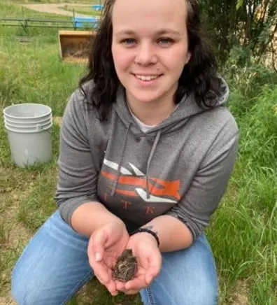 Sable holding a small animal in her hands