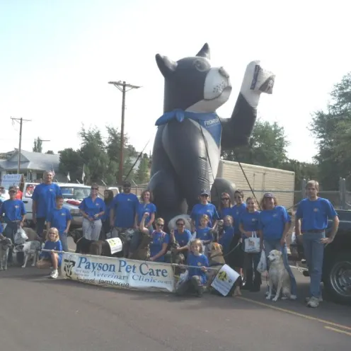 Staff members of Payson Pet Care posing with an inflatable parade float 