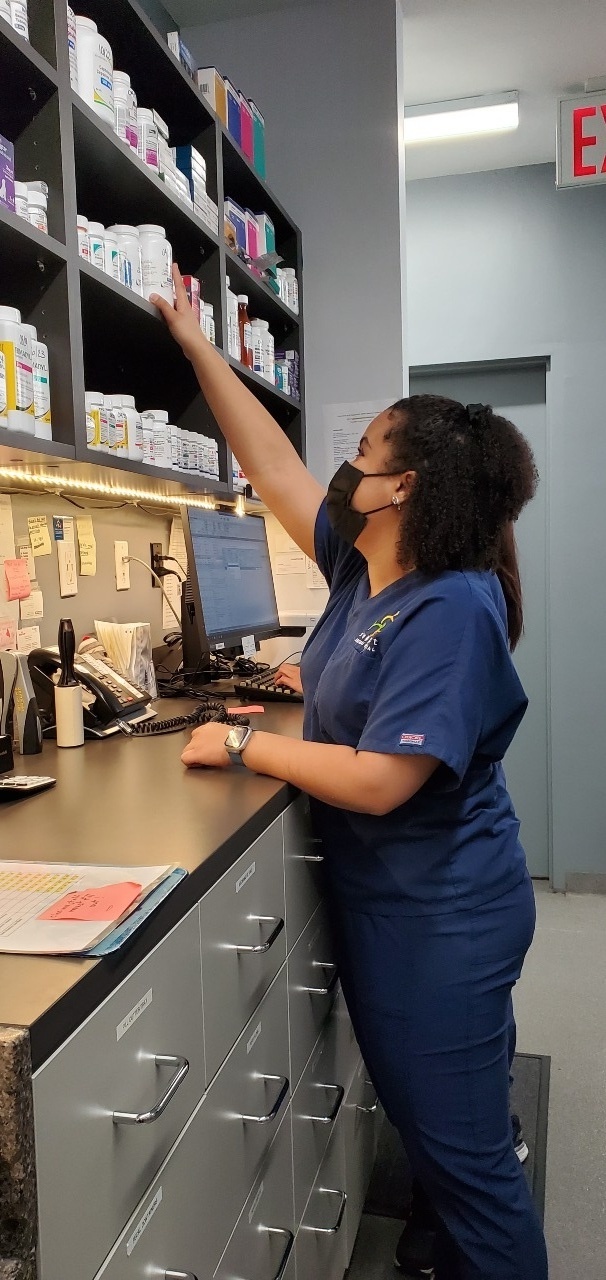 Seaport Animal Hospital reaching in a cabinet.