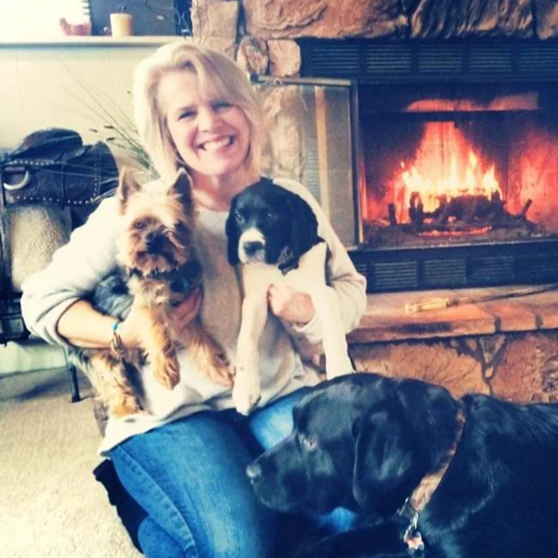 Cristi sitting in front of a fire place with her 3 dogs Cristi sitting in front of a fire place with her 3 dogs