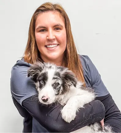 Rachel Levan smiling holding a white and black speckled puppy Rachel Levan smiling holding a white and black speckled puppy