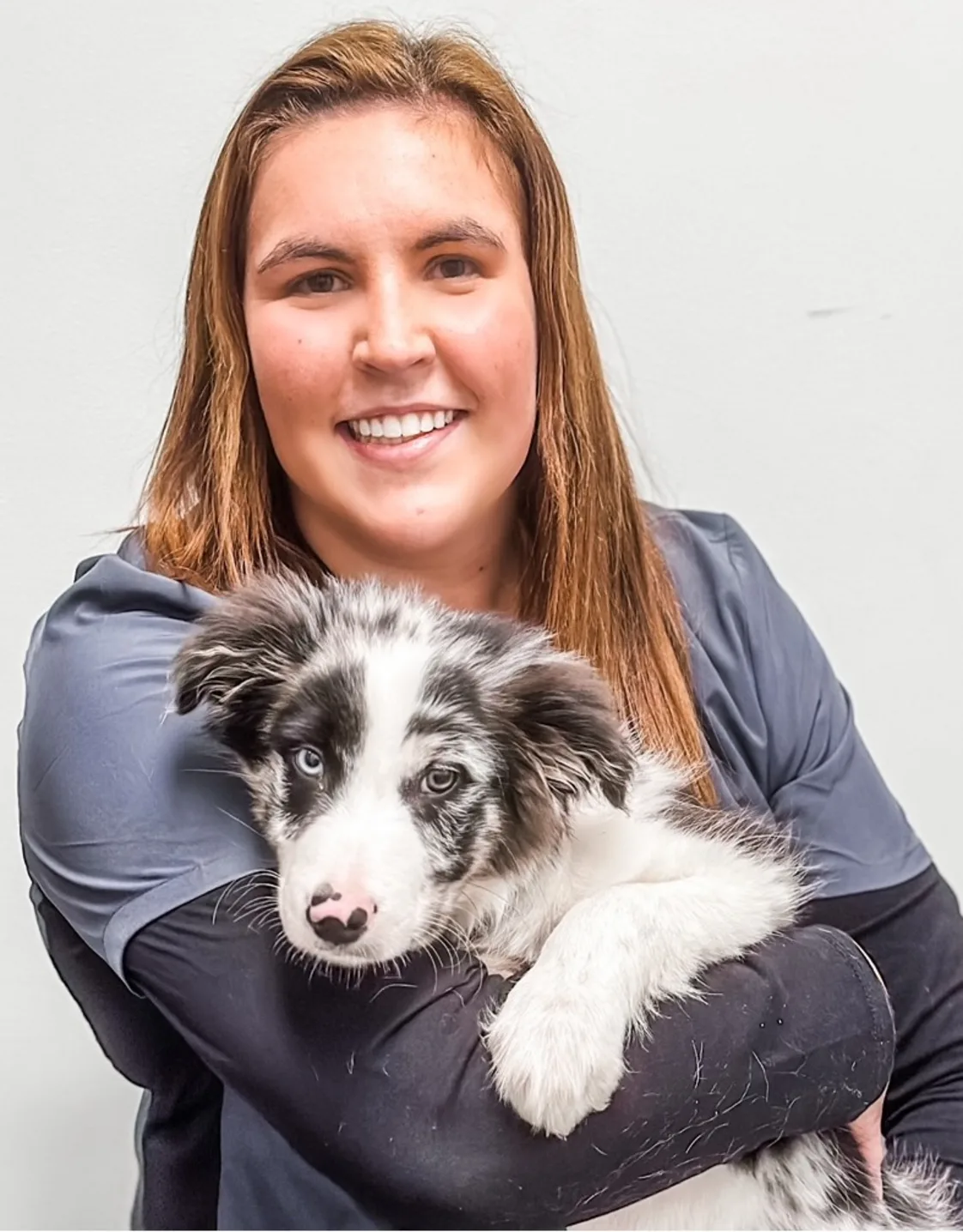 Rachel Levan smiling holding a white and black speckled puppy Rachel Levan smiling holding a white and black speckled puppy