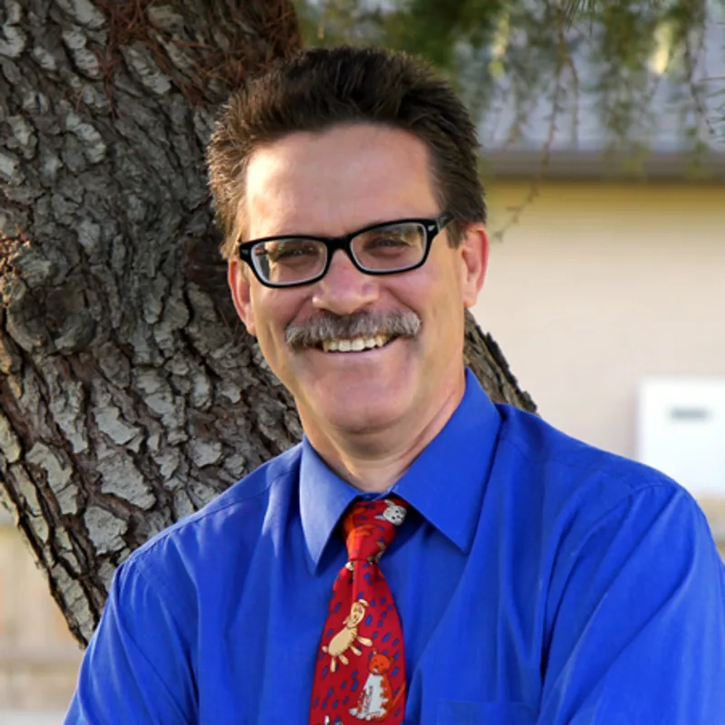 man with a blue button up and tie smiling at camera man with a blue button up and tie smiling at camera