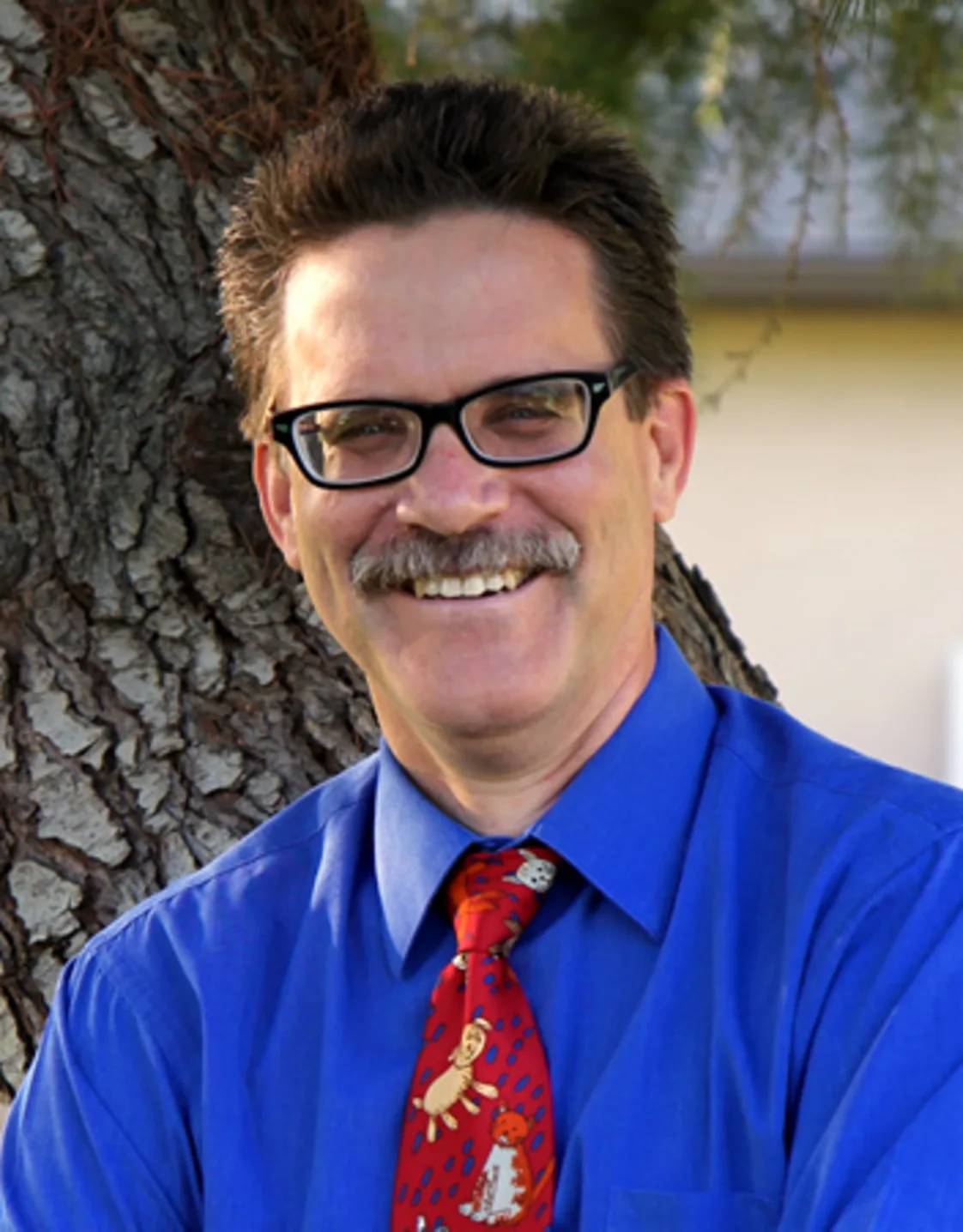 man with a blue button up and tie smiling at camera man with a blue button up and tie smiling at camera