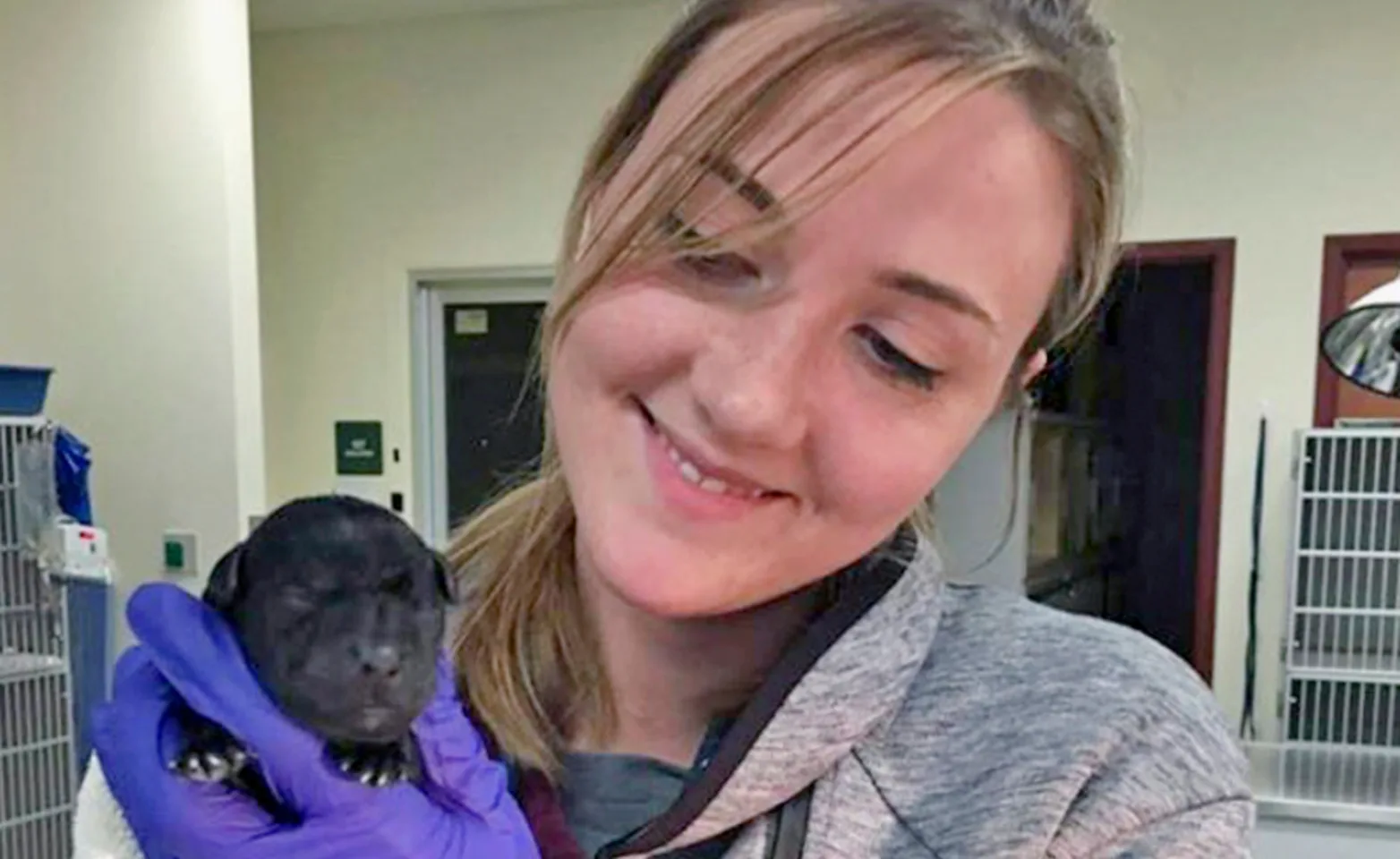 Woman Carrying a Small Black Puppy Woman Carrying a Small Black Puppy
