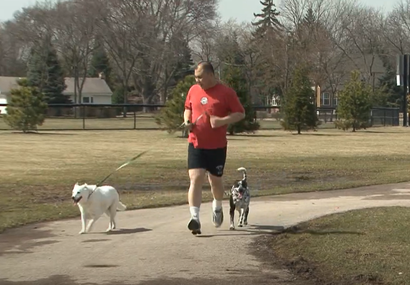 Man running with two dogs