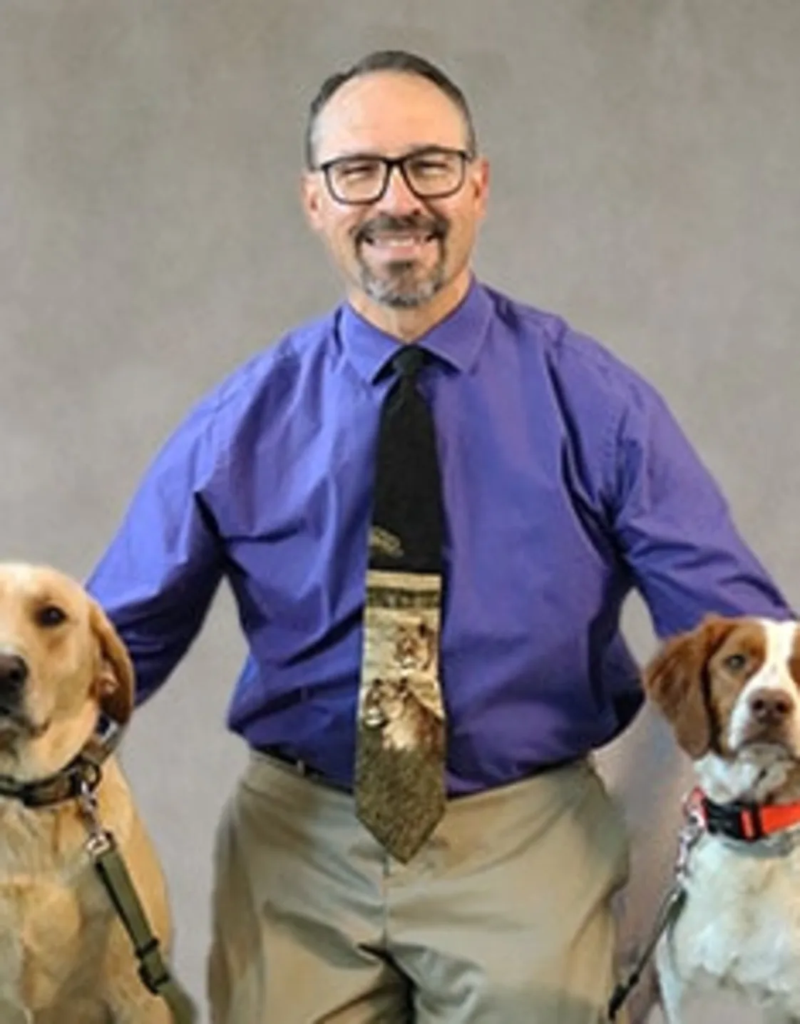 Dr. Bradley Coolman kneeling down next to two dogs Dr. Bradley Coolman kneeling down next to two dogs