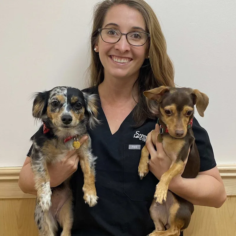 Dr. Elizabeth holding two small dogs. Dr. Elizabeth holding two small dogs.