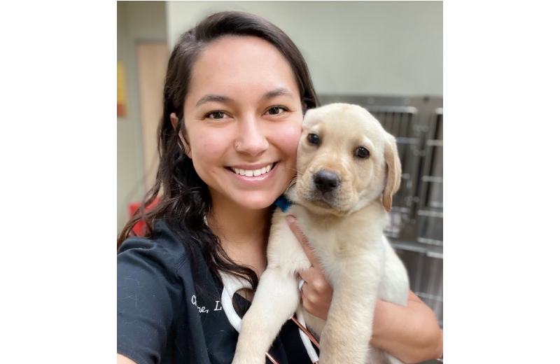 Woman Smiling Holding a Dog