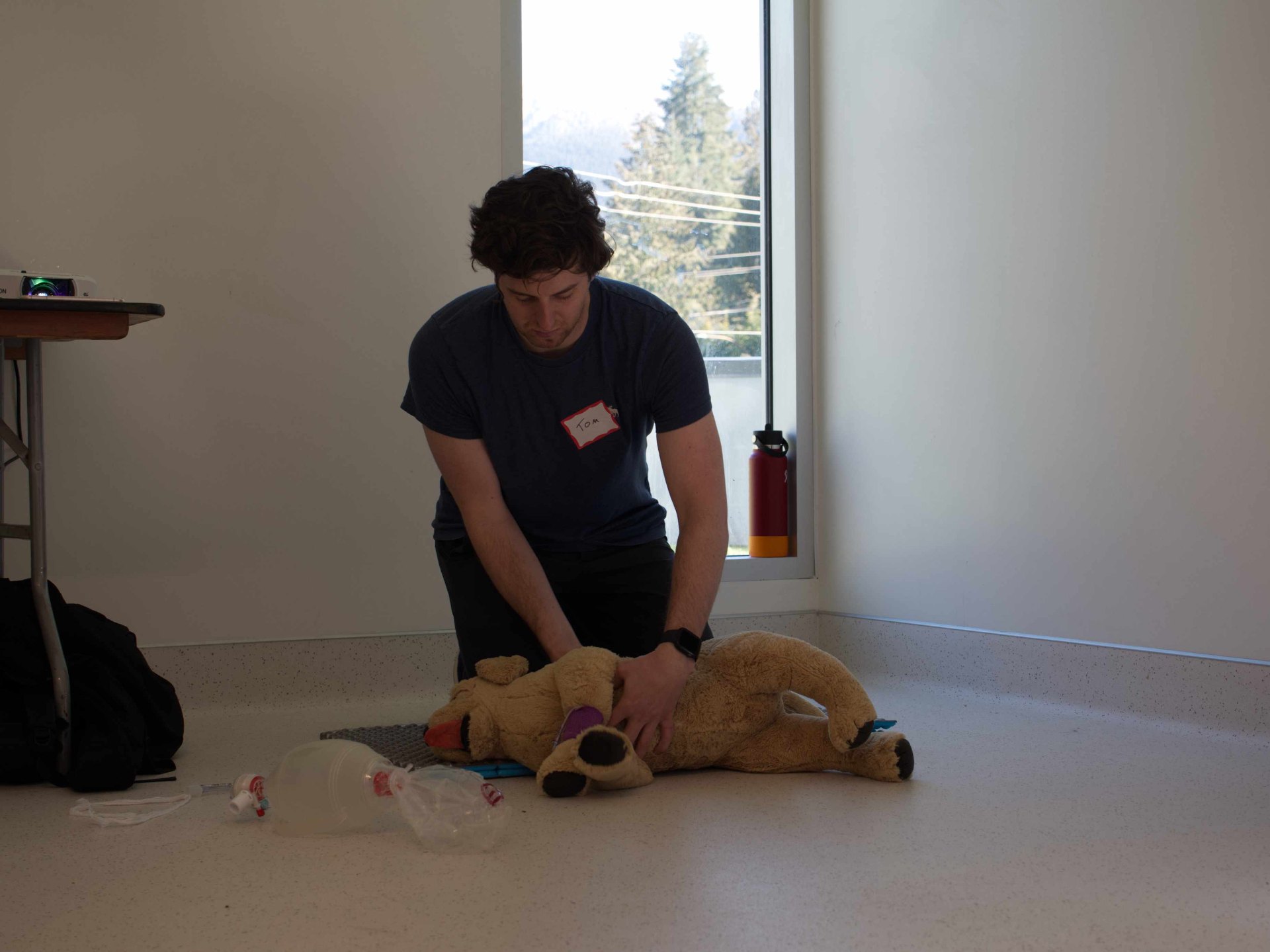 Staff members practicing CPR on a stuffed animal