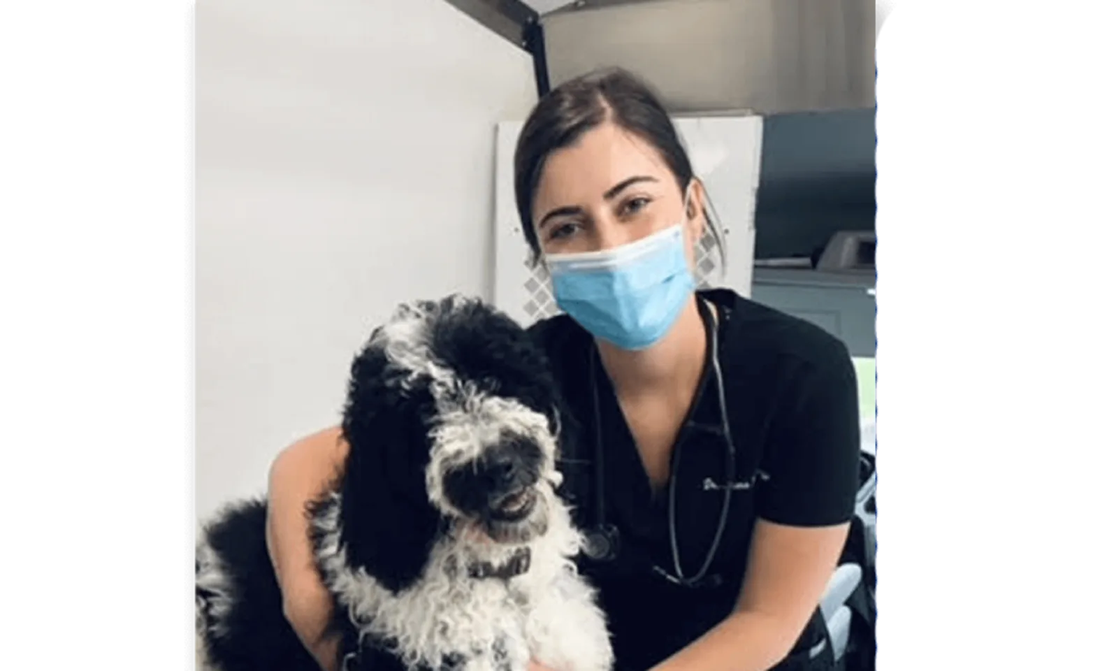 A veterinarian posing with a black and white dog A veterinarian posing with a black and white dog