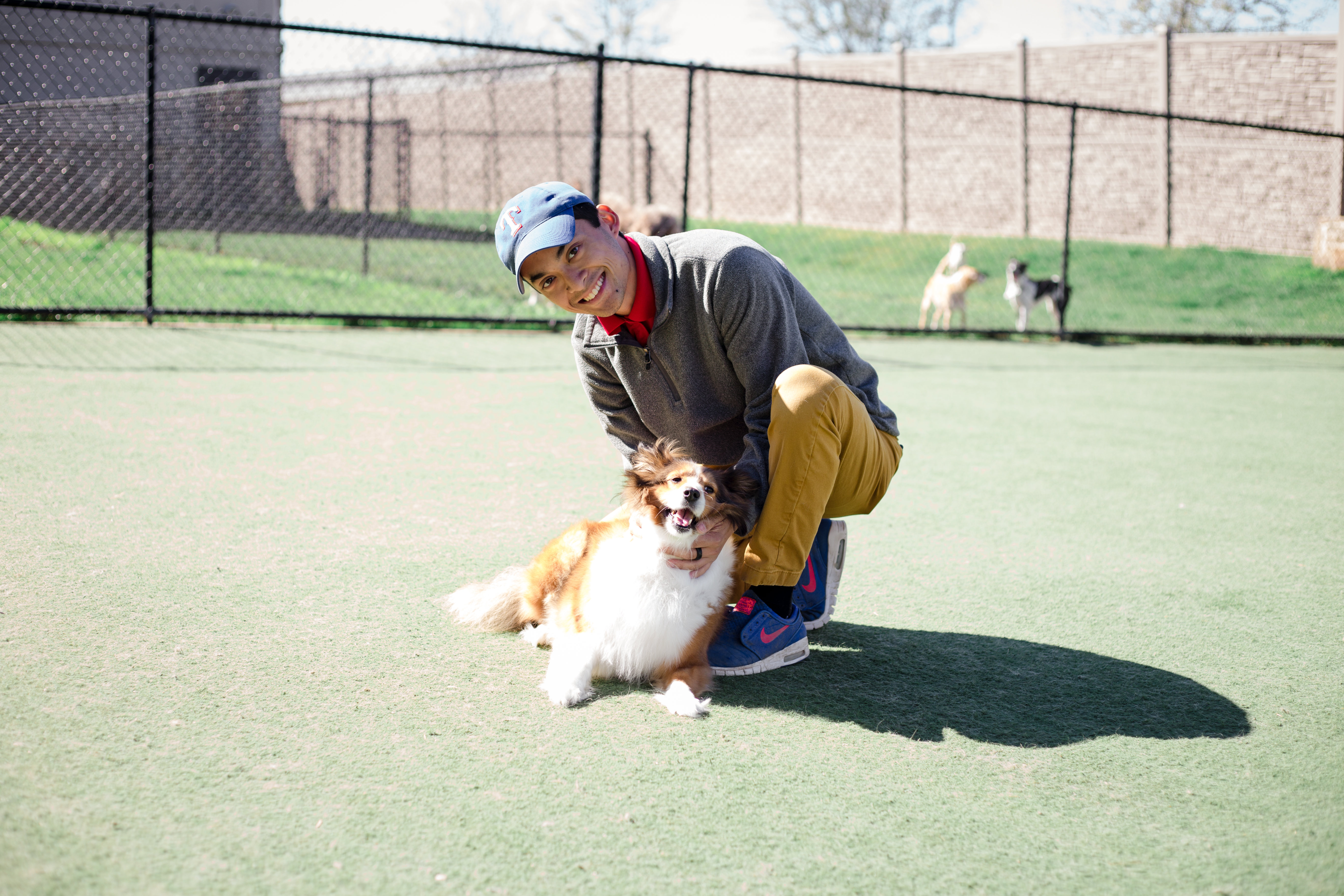 Employee holding dog at dog daycare Elite Suites Heath