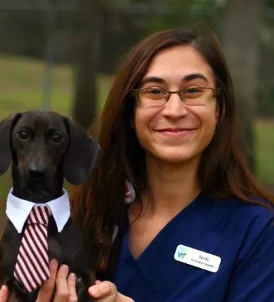 Sarah M. staff photo with dog with a tie on