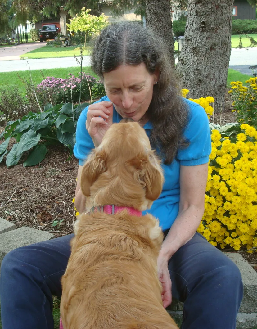 Suzanne Brahm kissing a golden retriever