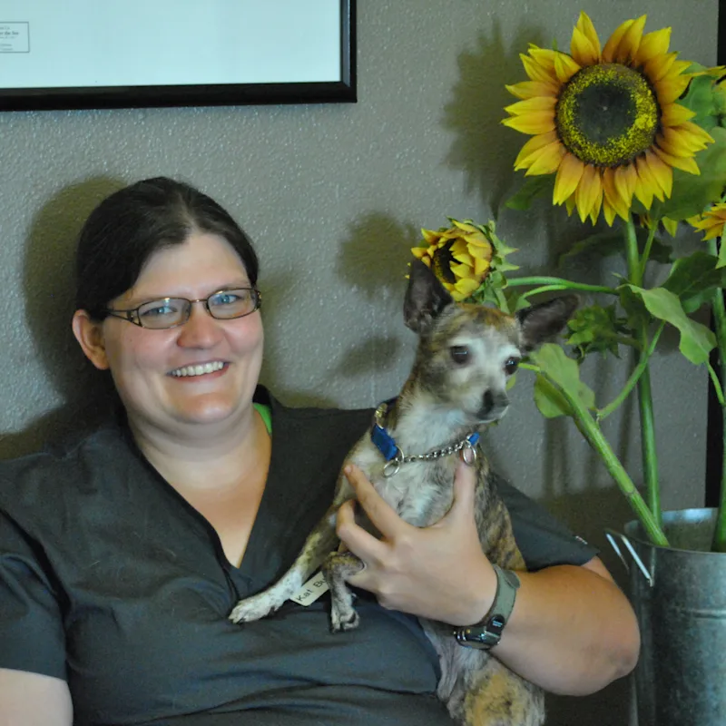 Katherine Burt, DVM holding a small dog. Katherine Burt, DVM holding a small dog.