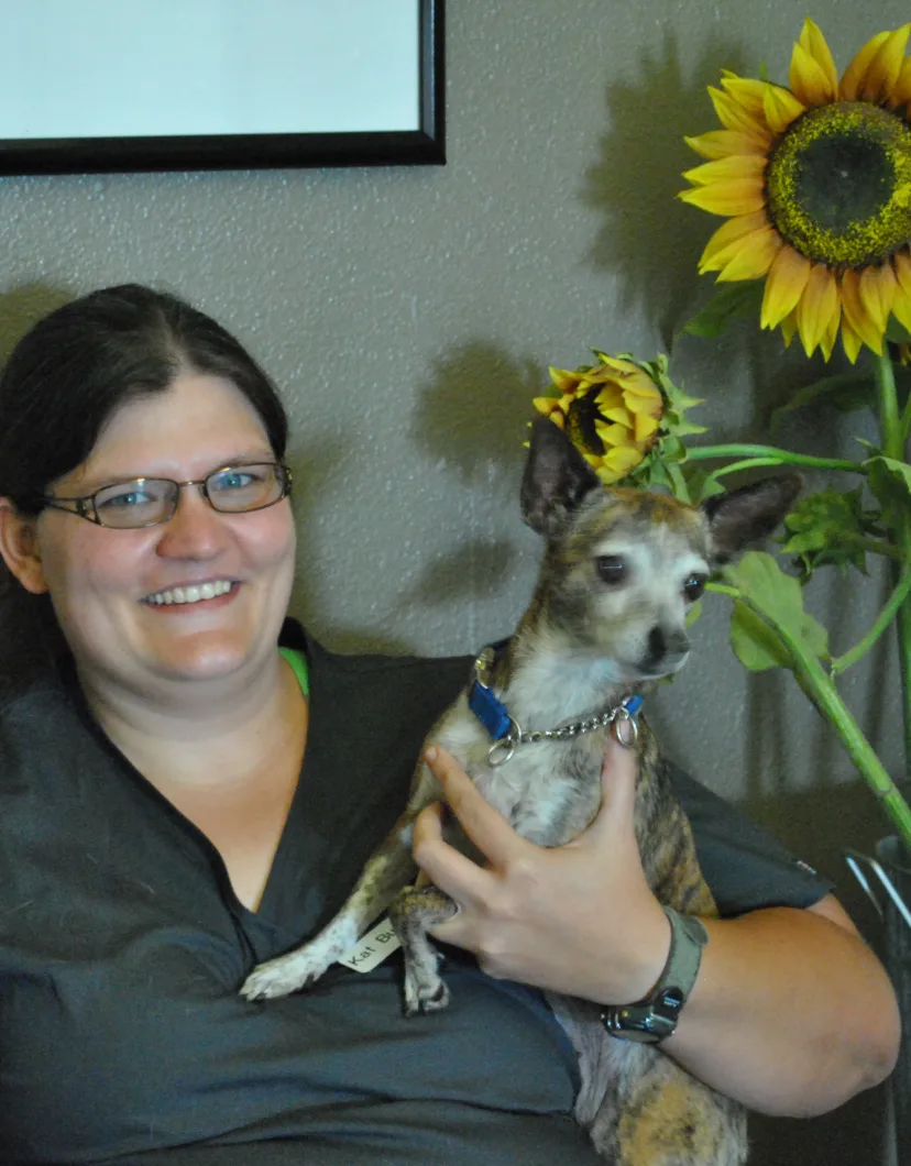 Katherine Burt, DVM holding a small dog.