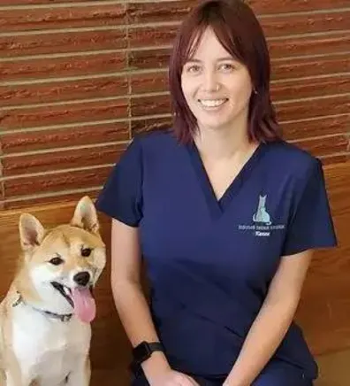 Karen smiling and sitting next to a dog. Karen smiling and sitting next to a dog.