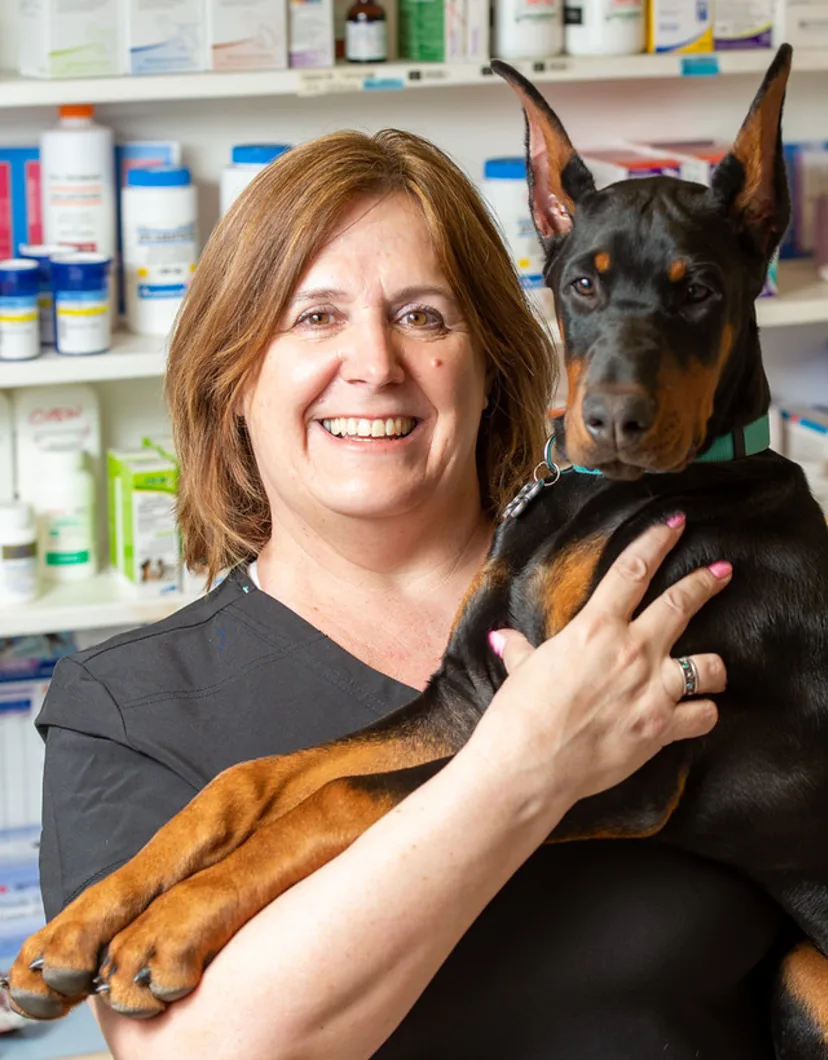 Kathy smiling at the camera with a dog