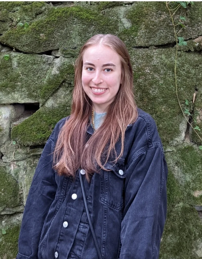 Nikki standing in front of a rock wall