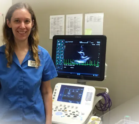 Veterinarian standing next to an ECG machine Veterinarian standing next to an ECG machine