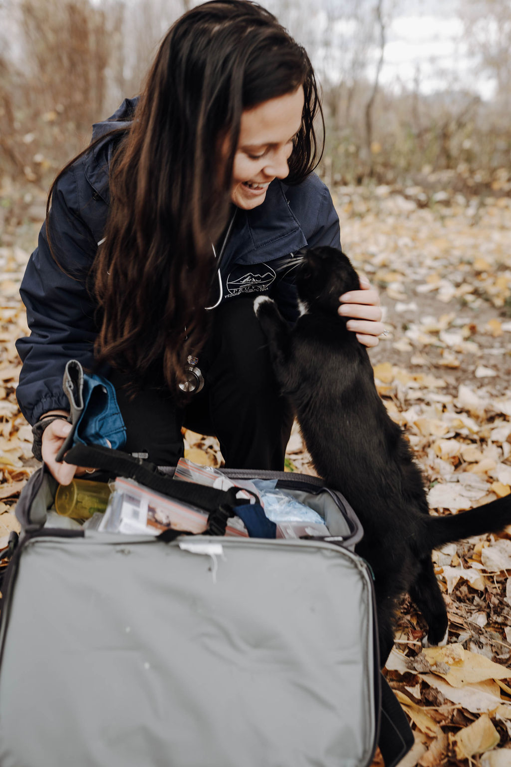 Staff smiling with black dog