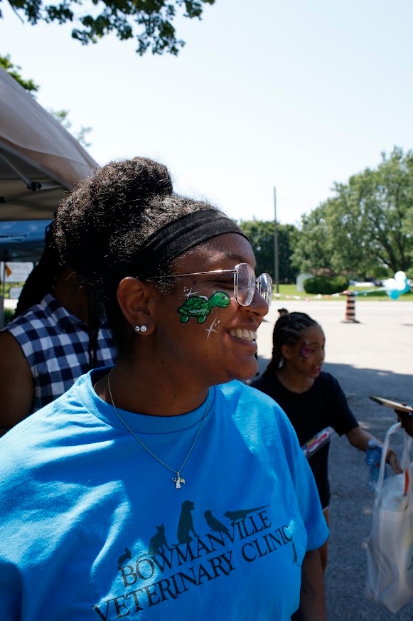  Staff member smiling outside with face paint on.