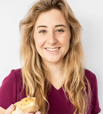 A portrait photo of Veterinary Assistant Abigail holding a Bearded Dragon A portrait photo of Veterinary Assistant Abigail holding a Bearded Dragon
