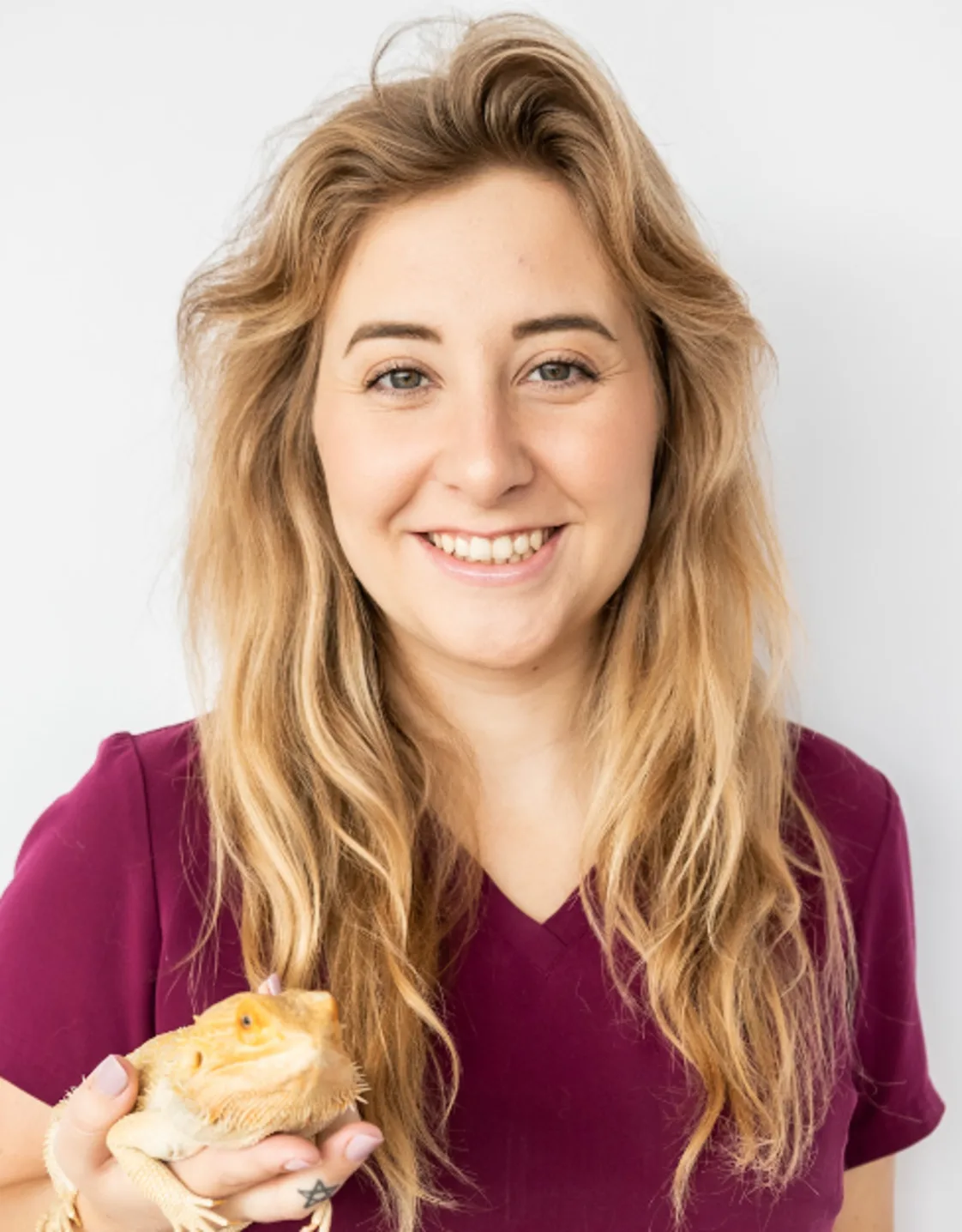A portrait photo of Veterinary Assistant Abigail holding a Bearded Dragon A portrait photo of Veterinary Assistant Abigail holding a Bearded Dragon