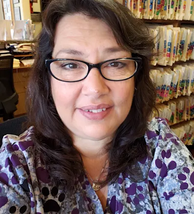 Tina's staff photo from Telegraph Canyon Animal Medical Center where she is sitting at her desk with patient folders behind her Tina's staff photo from Telegraph Canyon Animal Medical Center where she is sitting at her desk with patient folders behind her