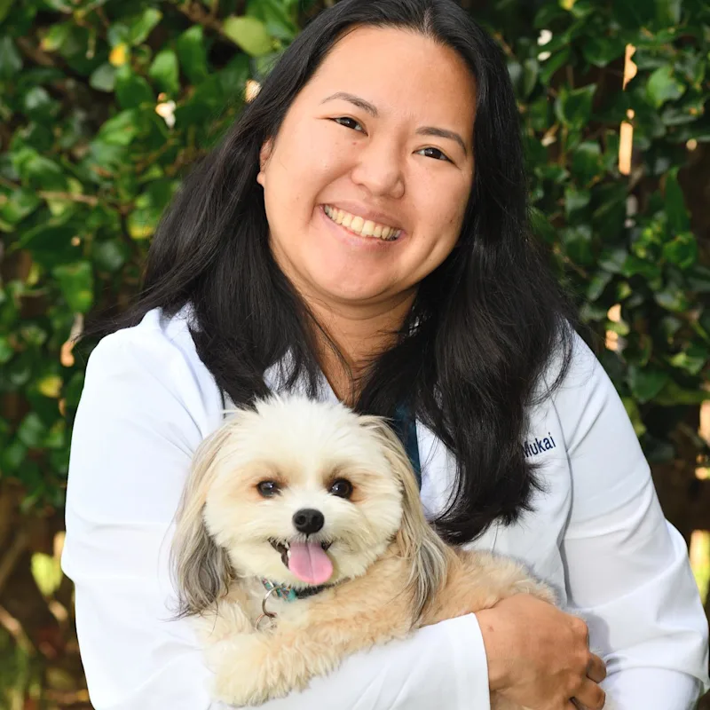 Dr. Cheryl Mukai holding and supporting a dog for the camera Dr. Cheryl Mukai holding and supporting a dog for the camera