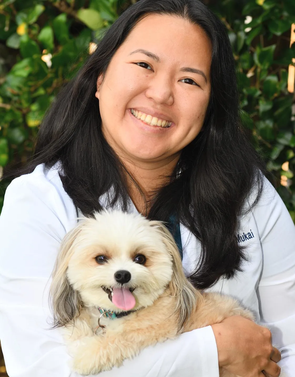 Dr. Cheryl Mukai holding and supporting a dog for the camera Dr. Cheryl Mukai holding and supporting a dog for the camera