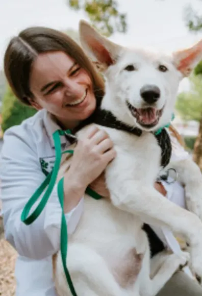 Staff smiling with White dog smiling at North Creek Pet Hospital