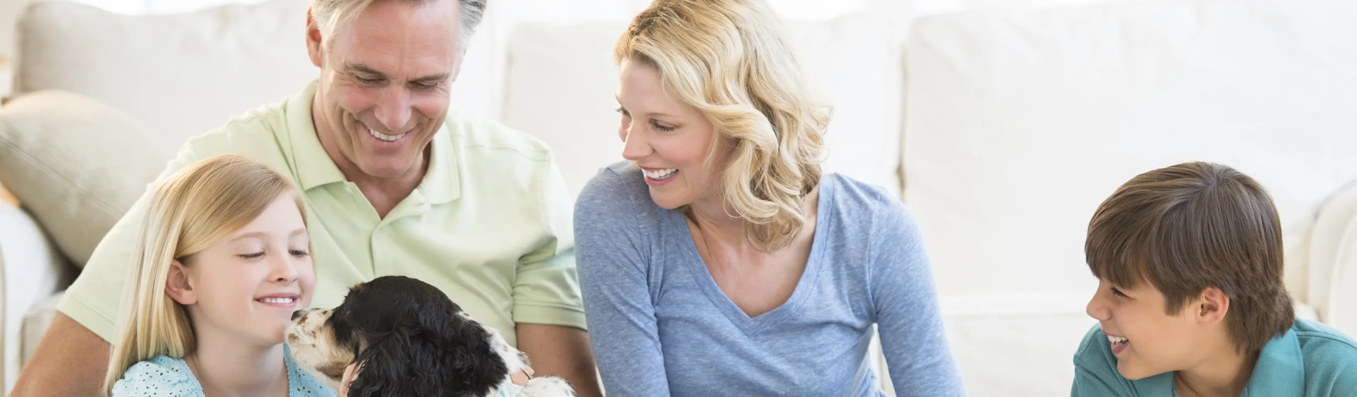 family and dog sitting in living room