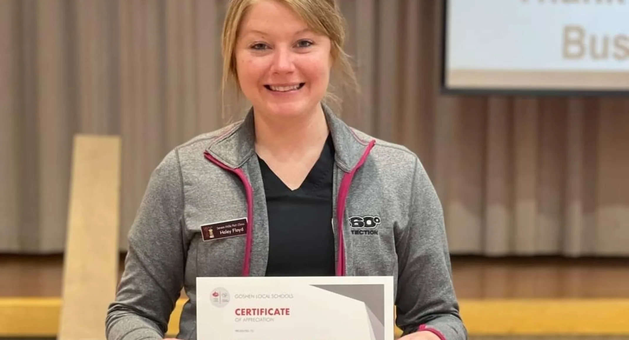 Staff Member holding Award Staff Member holding Award