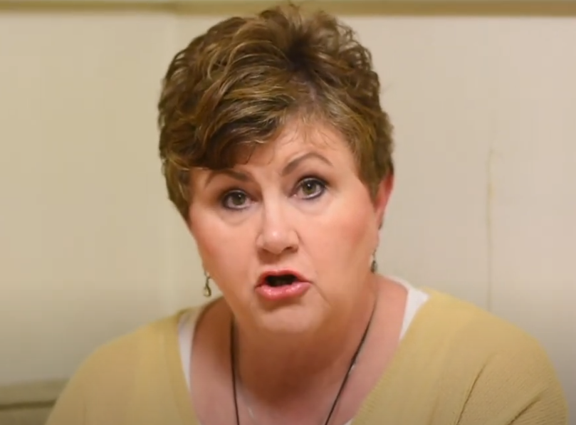 Woman in yellow giving a testimony