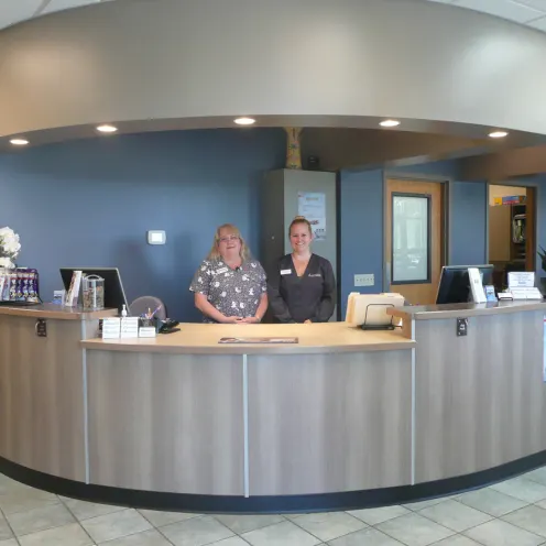 two staff members stand behind the front desk of SouthCare Animal Medical Center