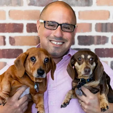 Dr. Moshe Oz, Vet at Rose Valley Veterinary Hospital, holding two dogs