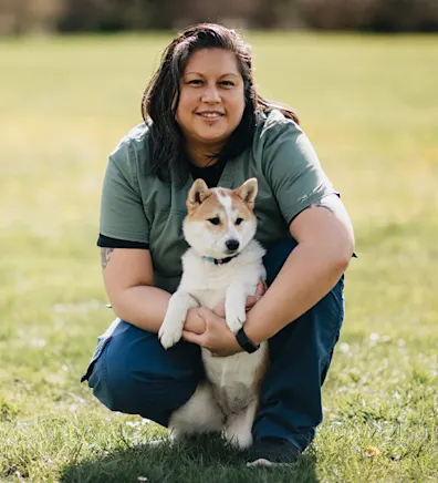 April Israel kneeling with a Shiba Inu dog 