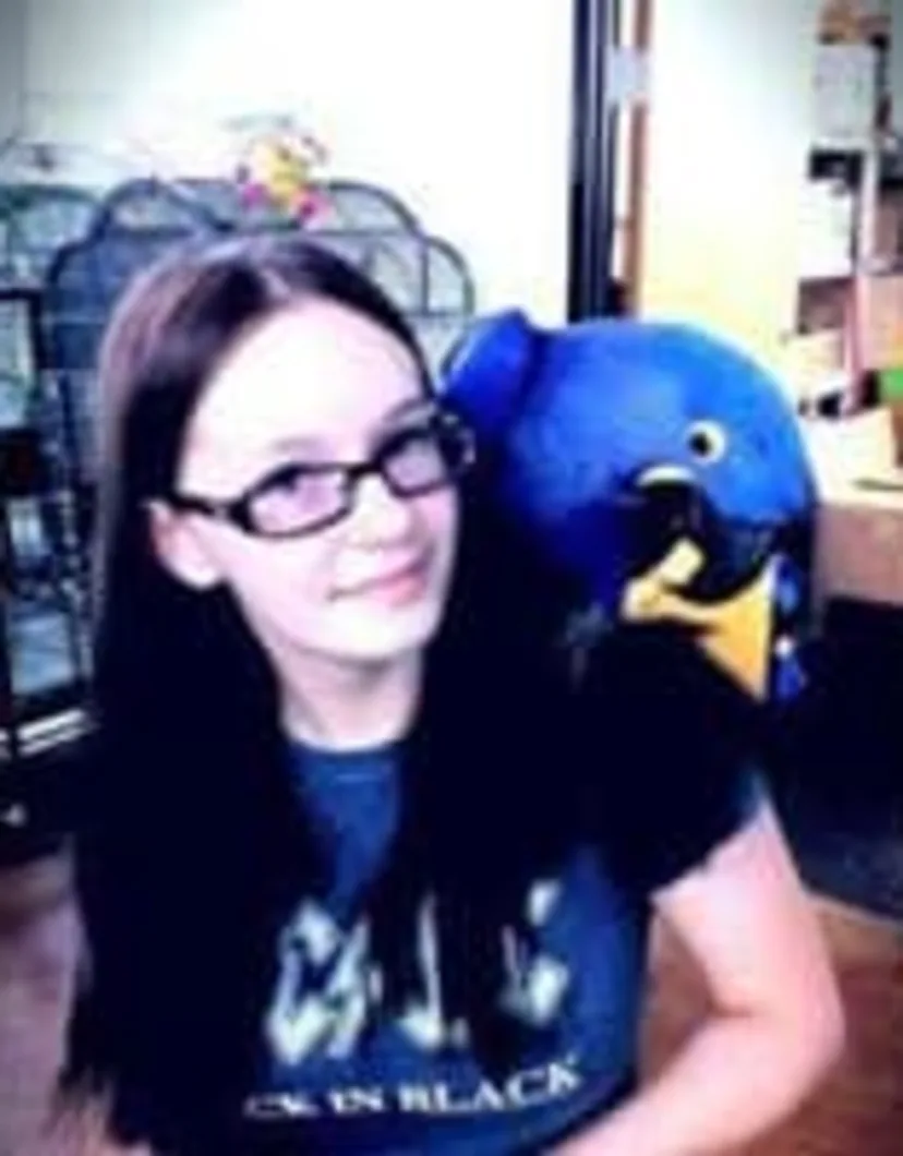 Destynee with a blue macaw on her shoulder