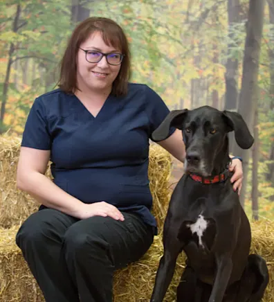 Breanna sitting with a large black and white dog