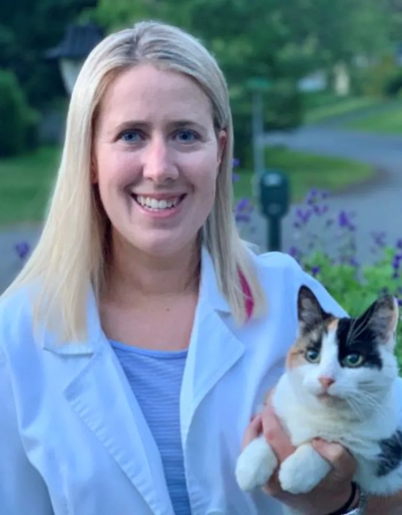 Dr. Bridget Barnes of Northampton Veterinary Clinic standing in front of a pathway, while holding a cat