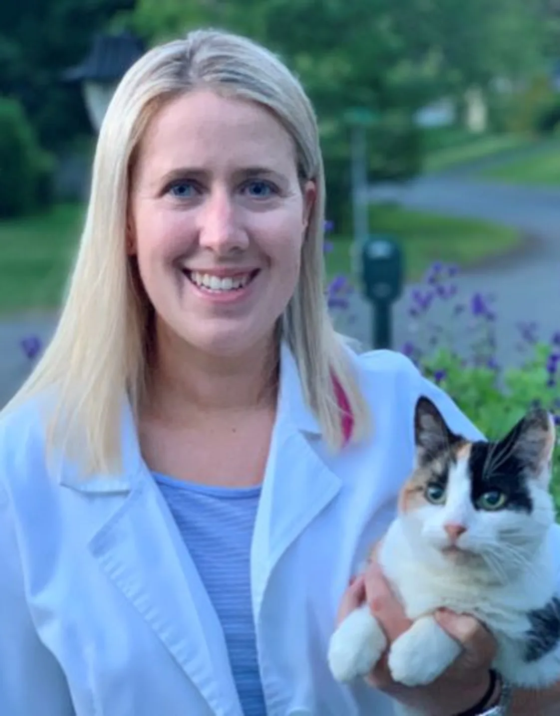 Dr. Bridget Barnes of Northampton Veterinary Clinic standing in front of a pathway, while holding a cat Dr. Bridget Barnes of Northampton Veterinary Clinic standing in front of a pathway, while holding a cat