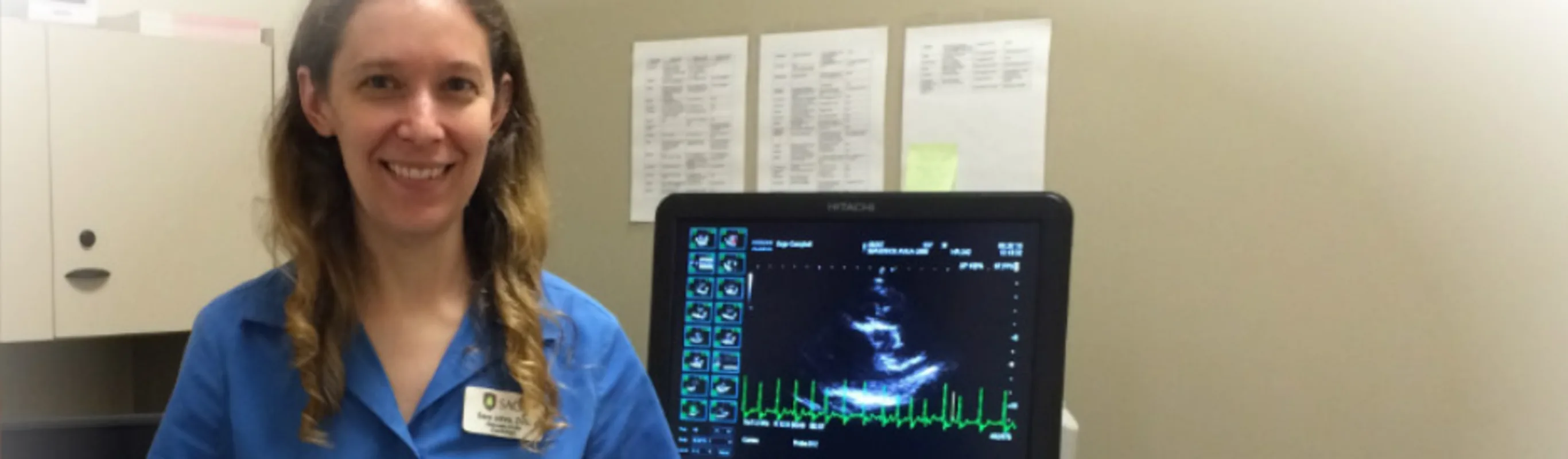 Veterinarian standing next to an ECG machine Veterinarian standing next to an ECG machine