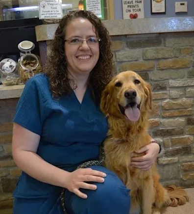 Anna kneeling down next to a golden retriever Anna kneeling down next to a golden retriever