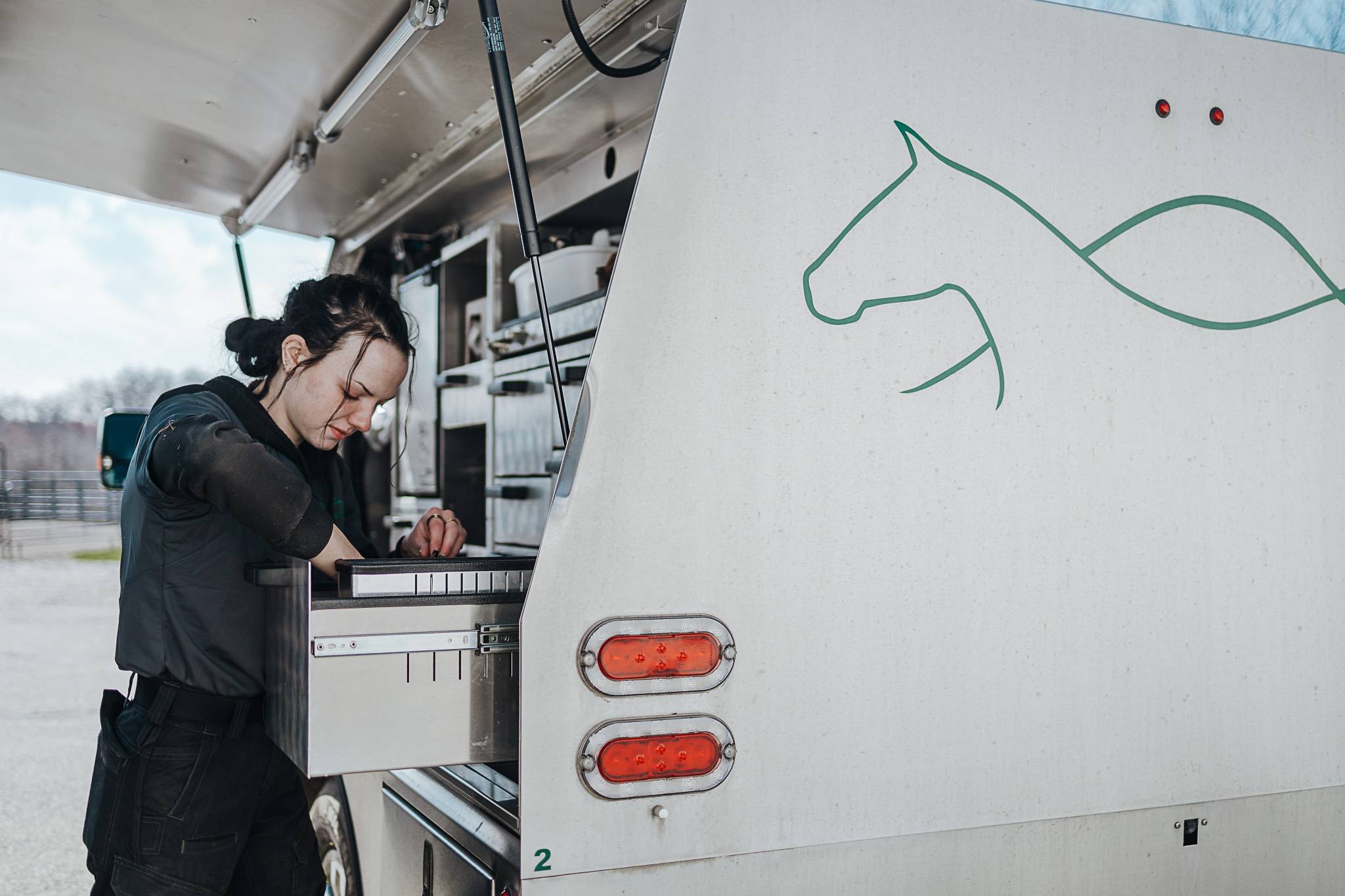 Staff member rummaging through storage on a company truck.