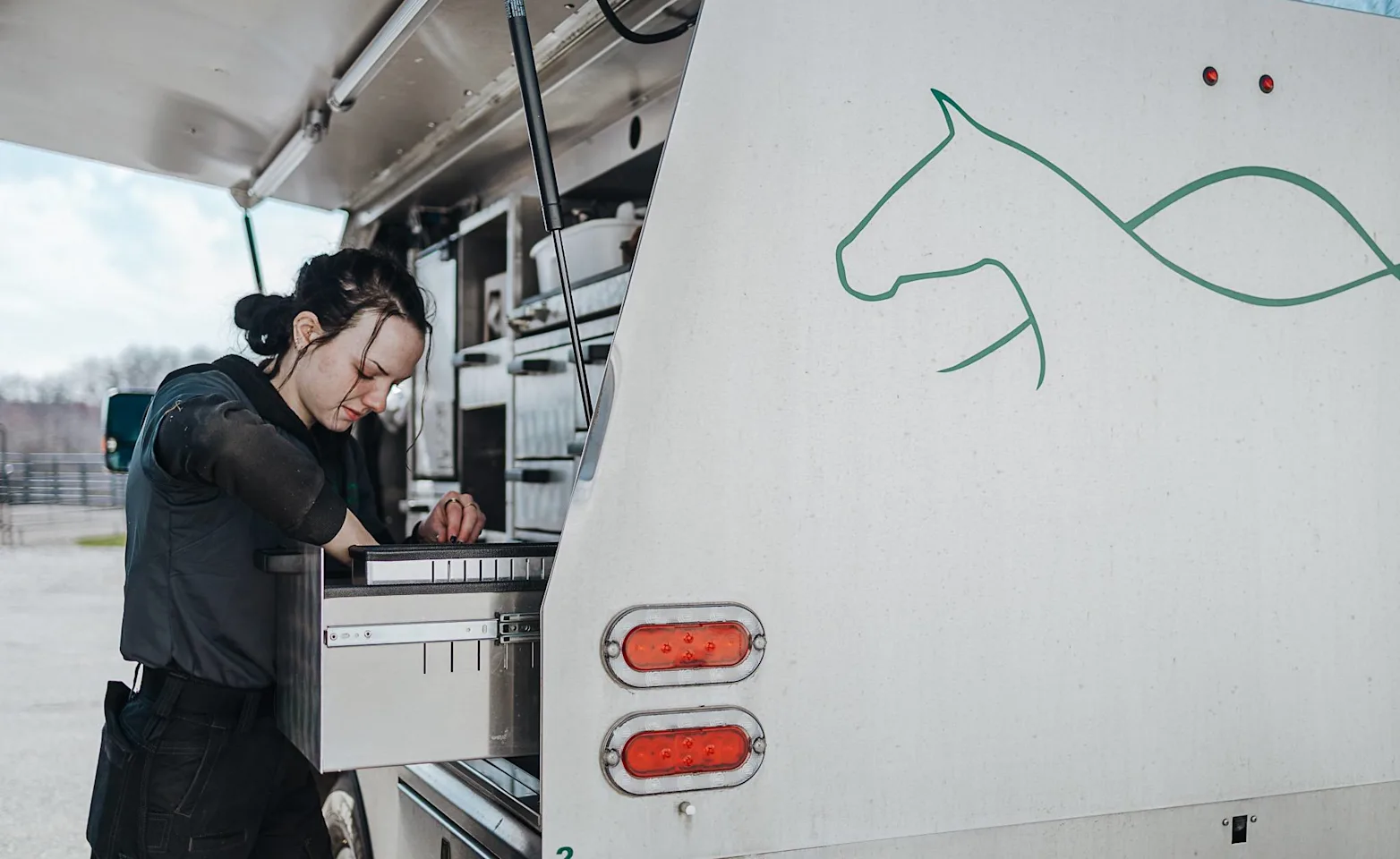 Staff member rummaging through storage on a company truck. Staff member rummaging through storage on a company truck.