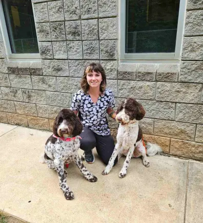 Heather, groomer at Animal Hospital of Towne Lake, with two dogs