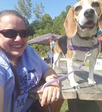 Woman smiling at camera while holding a dog Woman smiling at camera while holding a dog