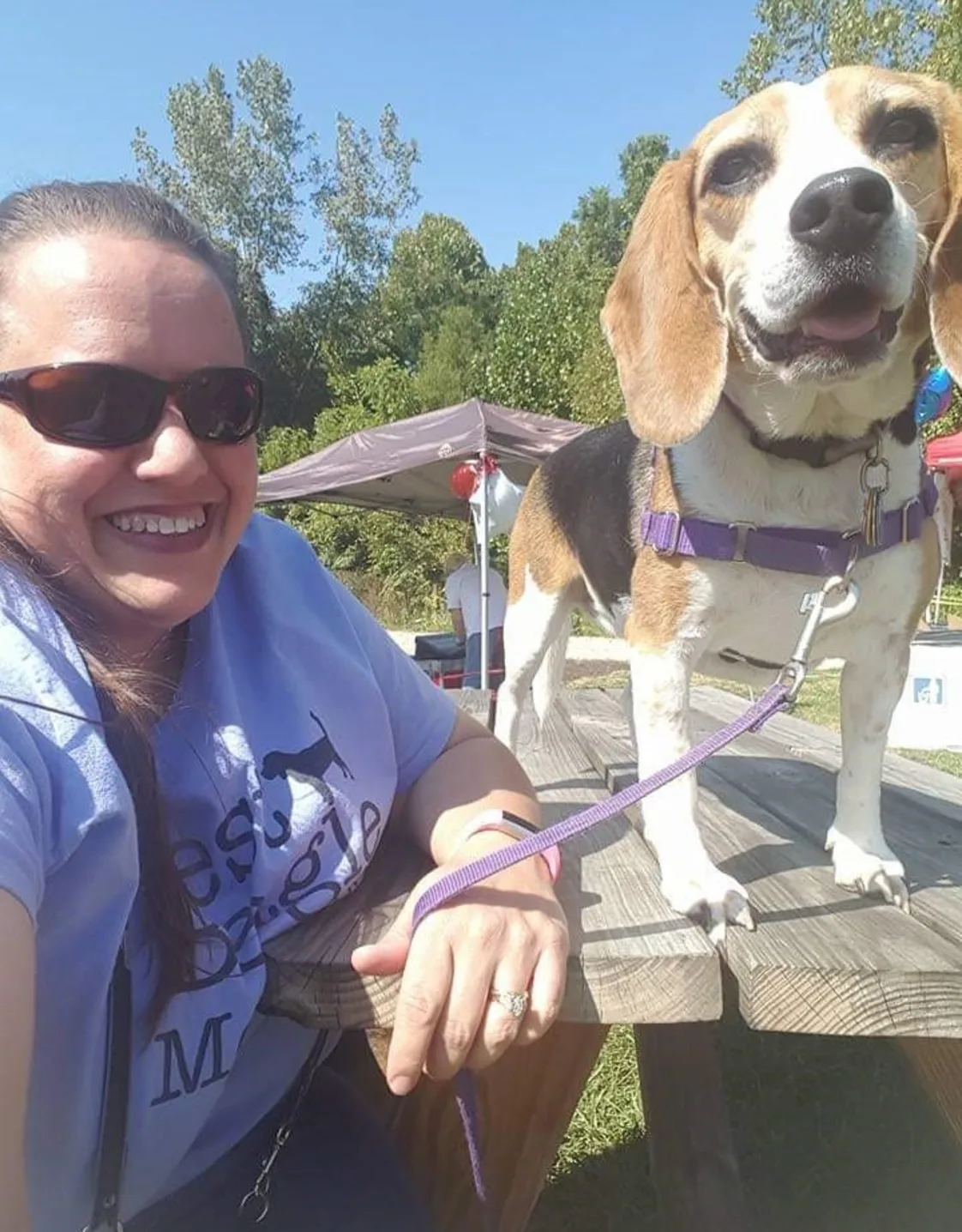 Woman smiling at camera while holding a dog Woman smiling at camera while holding a dog